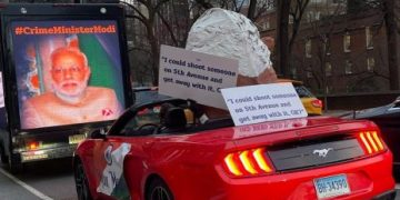 New York display: oversized Modi puppet in convertible with provocative banner