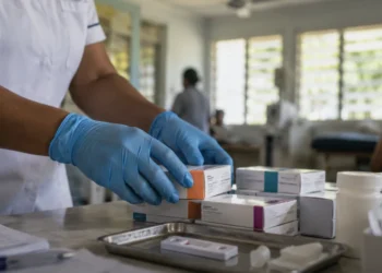 Fiji HIV National Emergency Declared as Cases Surge to Record 2,016 3 Healthcare worker arranging HIV antiretroviral medication and testing supplies at a Pacific clinic amid Fiji's HIV national emergency