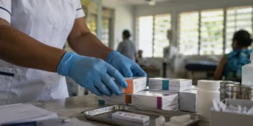Healthcare worker arranging HIV antiretroviral medication and testing supplies at a Pacific clinic amid Fiji's HIV national emergency