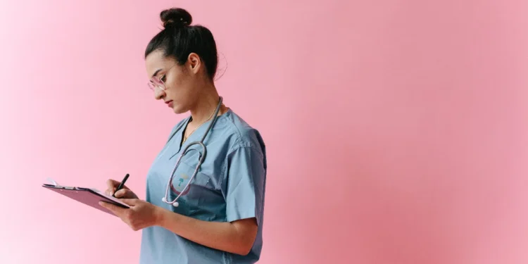 Indian Nurse Canada Recognition: A Critical 5-Year Wait Despite a Faster BC Option 1 A nurse in scrubs with a stethoscope writing on a clipboard, representing the credential review an Indian nurse completes for Canada registration