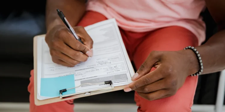 Indian Passport OCI New Zealand: 5 Critical Facts to Verify 1 A person completing an OCI application and Indian passport form, representing the New Zealand application process