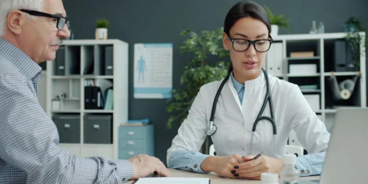 A doctor consults with a patient in a clinic office, illustrating UAE family health insurance outpatient cover