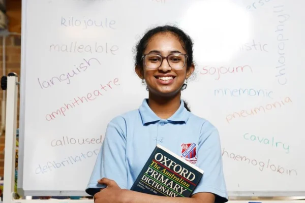 Aarika Harsha, the 2026 Years 5–6 spelling bee winner, holding a dictionary at Holsworthy Public School