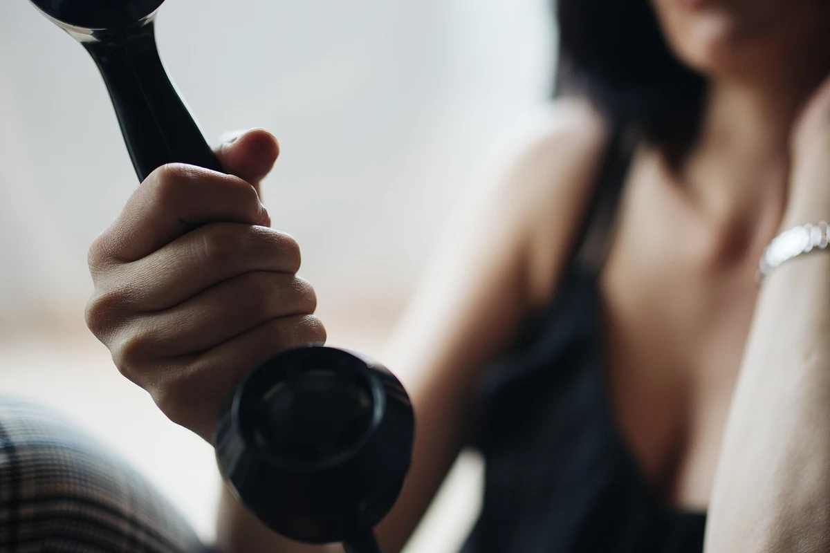 Person holding a black telephone handset