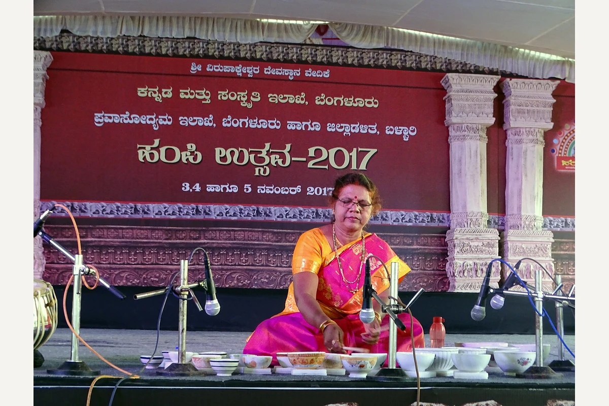 Shashikala Dani seated on stage playing jaltarang at Hampi Utsav