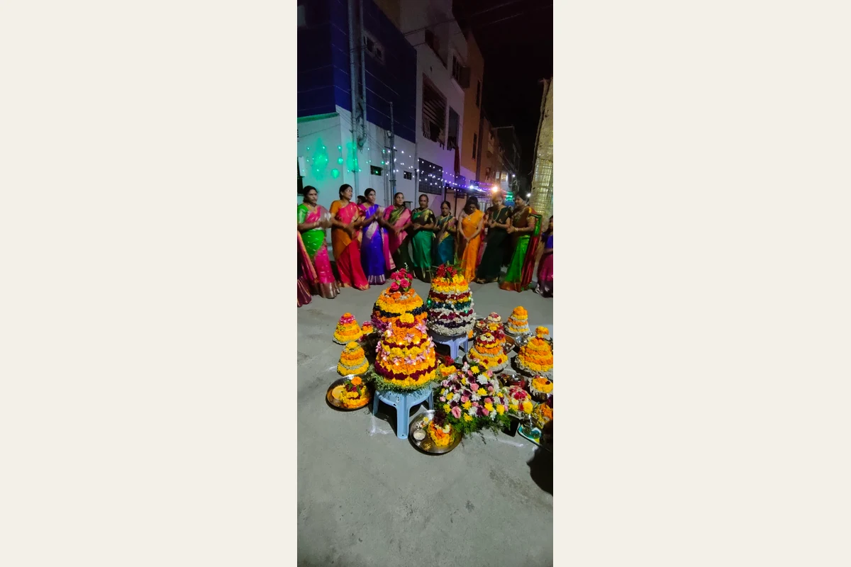 Women gathered around Bathukamma flower stacks in Telangana